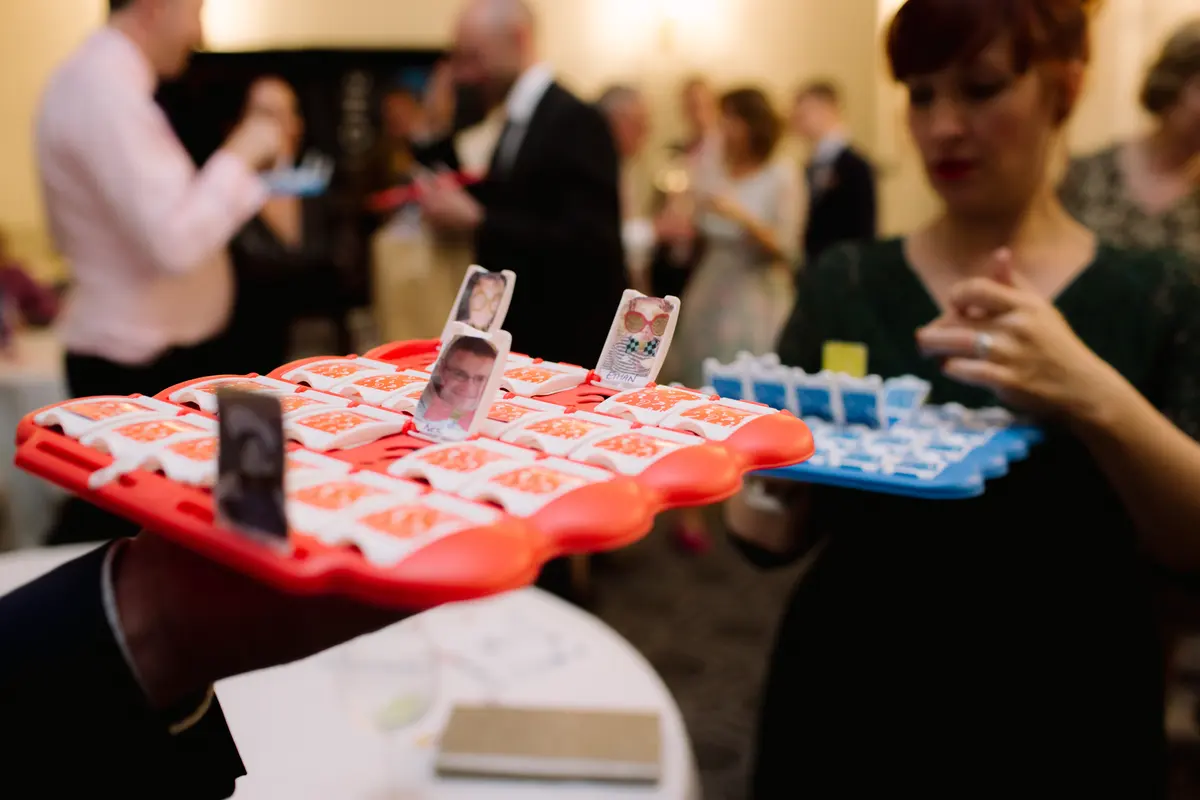 Guests playing a Guess Who game made with photos of wedding guests