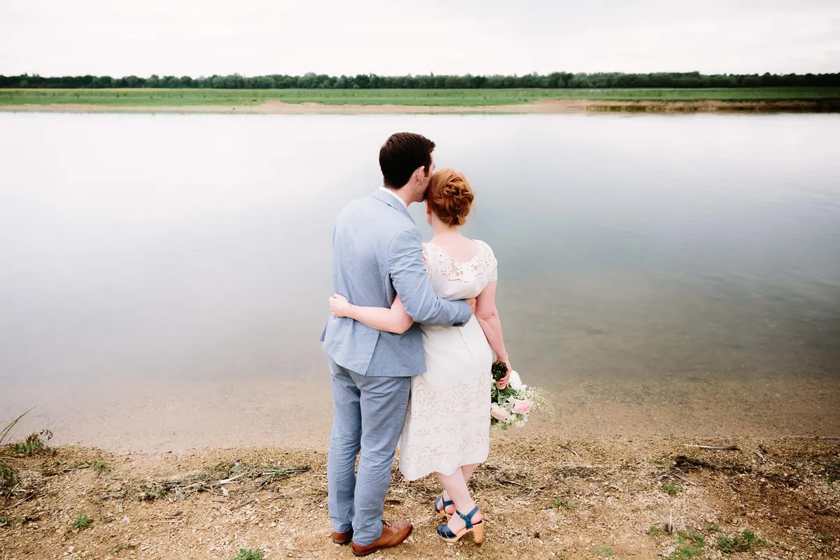 Bride and groom hugging by the river at The Perch wedding venue