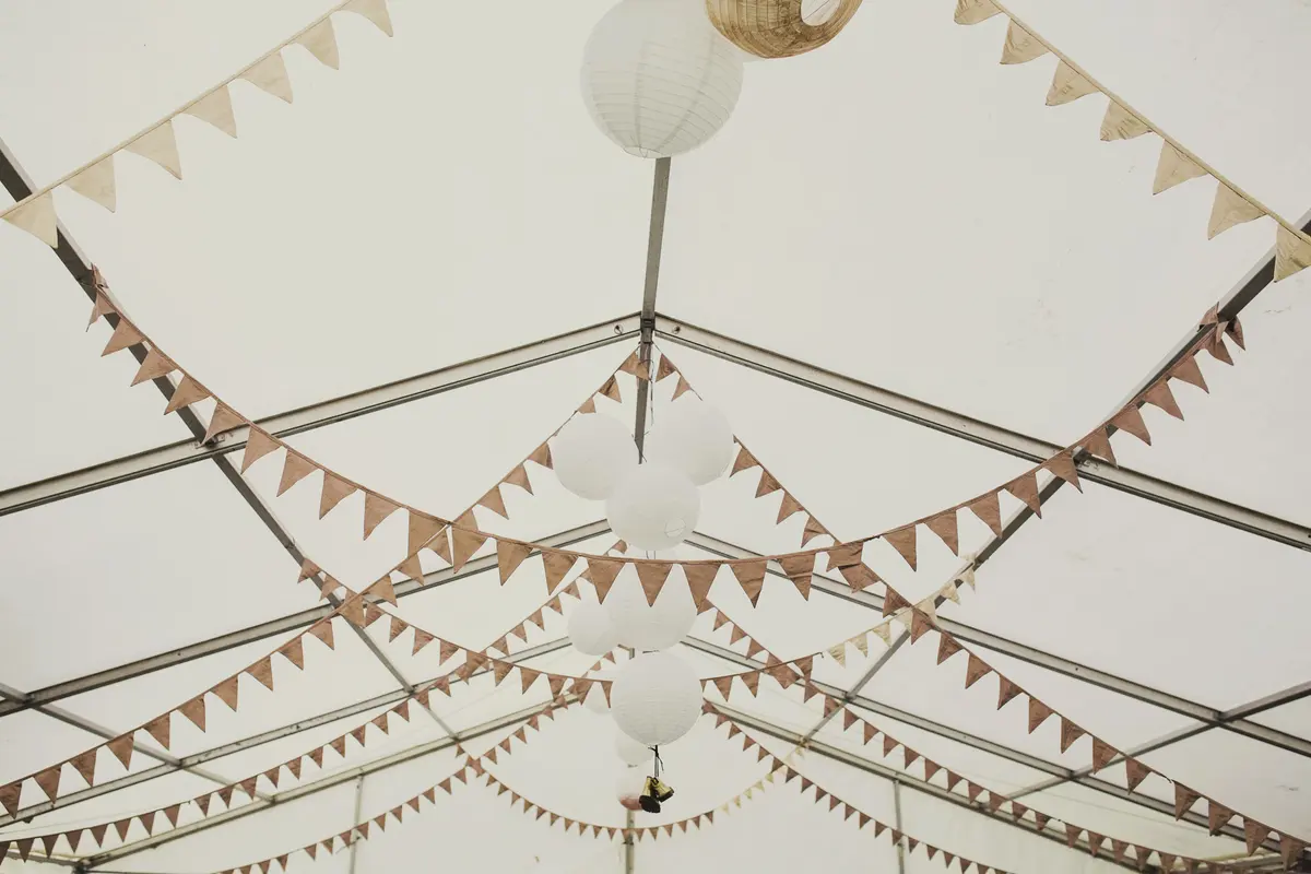 Marquee ceiling hung with paper lanterns and strings of bunting