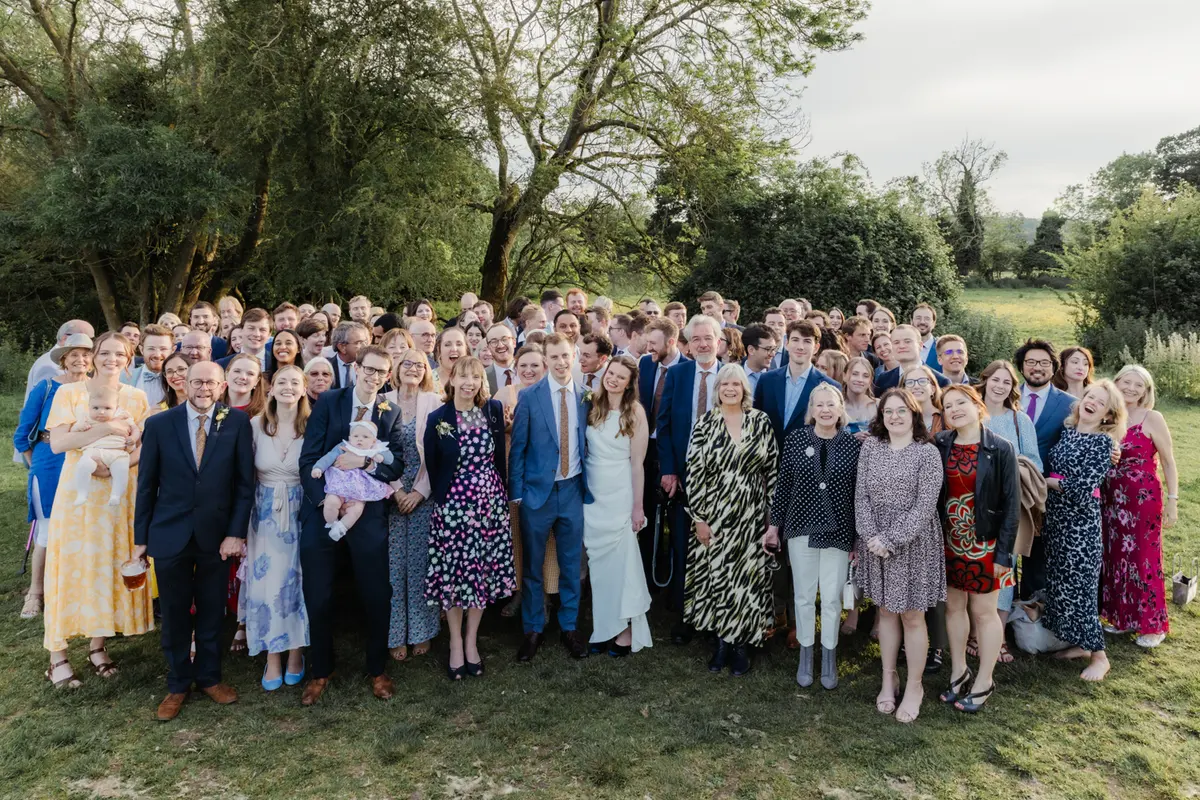 Large group photo of the couple with all their wedding guests on the lawn at the Perch