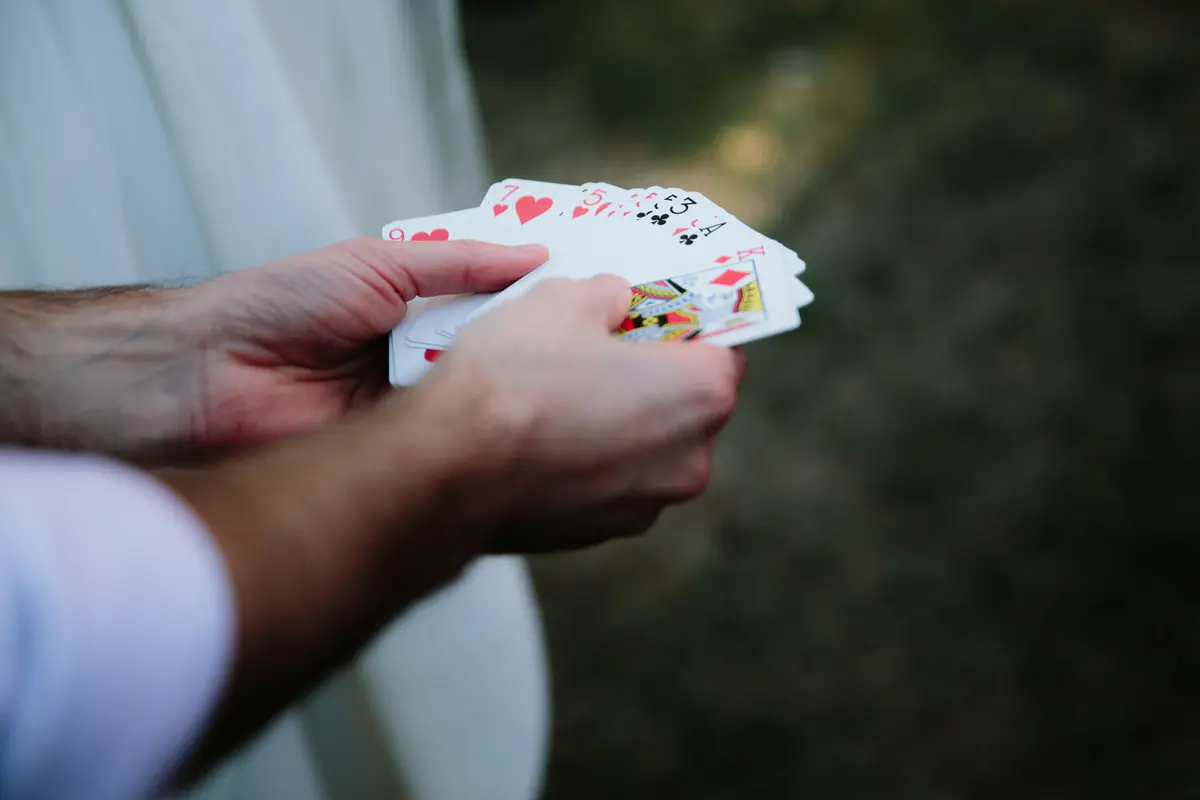 Close-up of hands fanning out a deck of playing cards during a magic trick