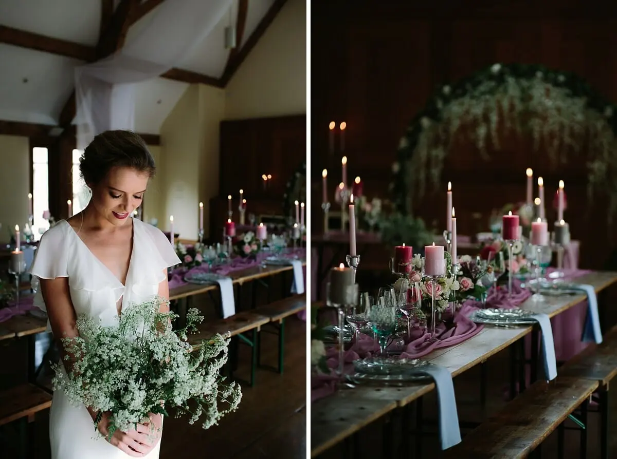 Bride holding cow parsley beside long candlelit tables with pink runners and a floral arch at Sulgrave Manor