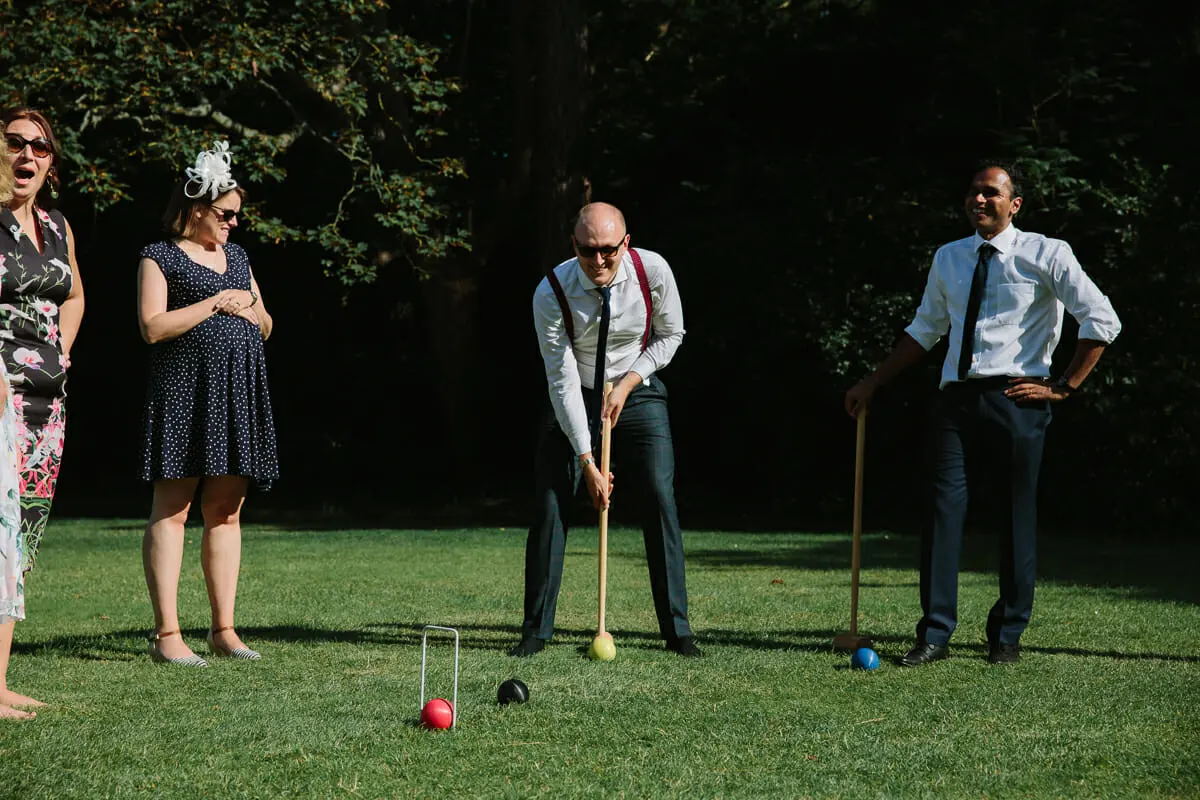 Guests playing croquet on a sunny lawn at St Hugh's College