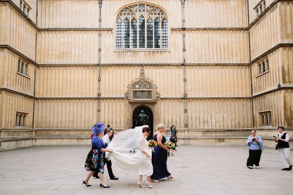 wedding photographer in oxford - bride walking through bodleian library
