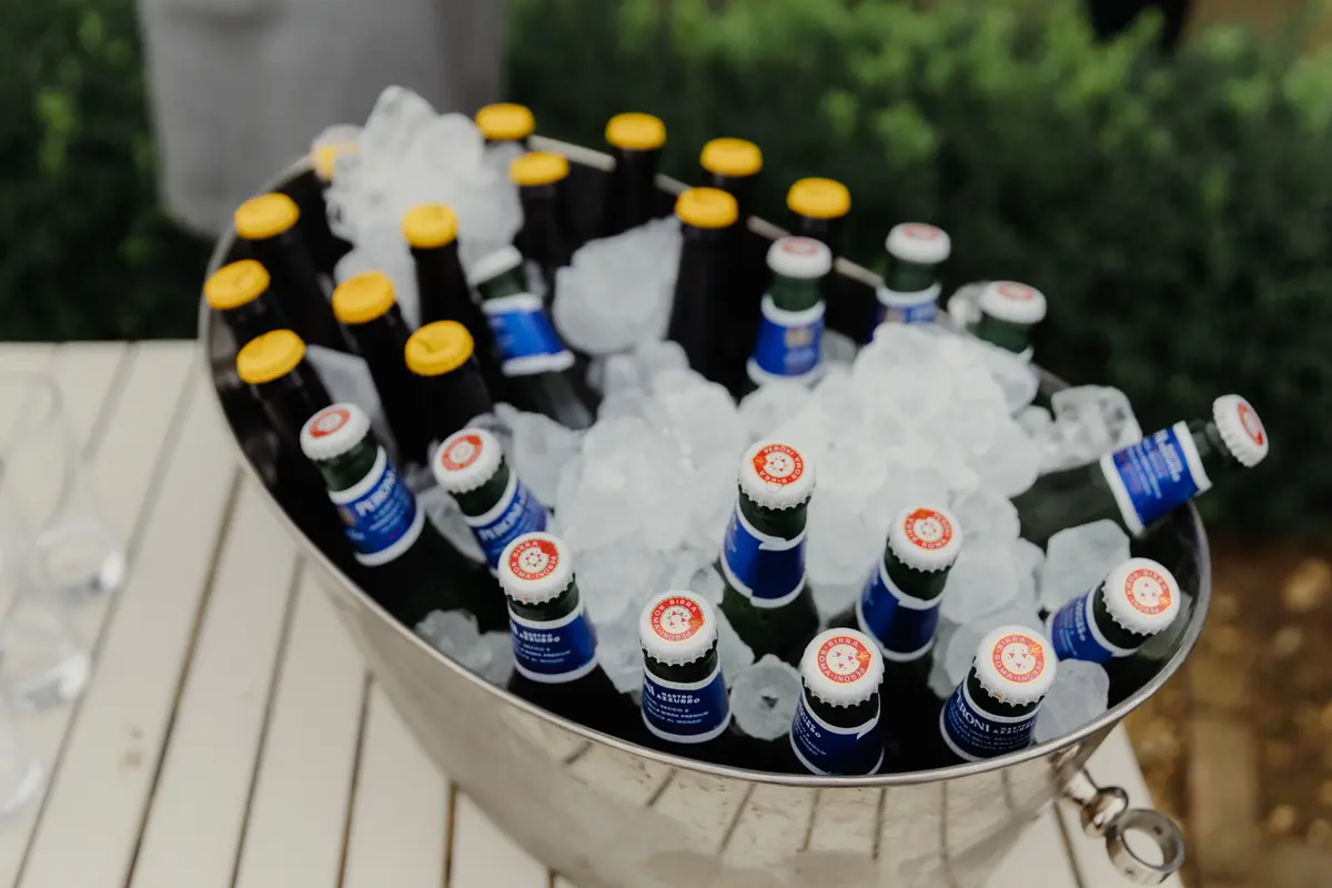 Bottles of beer chilling on crushed ice in a large metal bucket