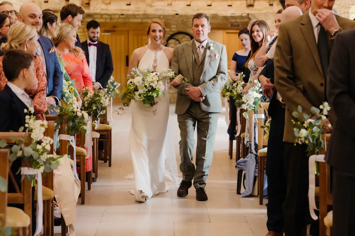 bride walking down isle at Caswell House Barn