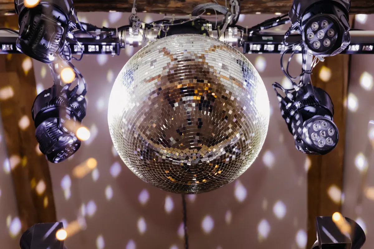 Mirror ball hanging among disco lights from the beams at Caswell House