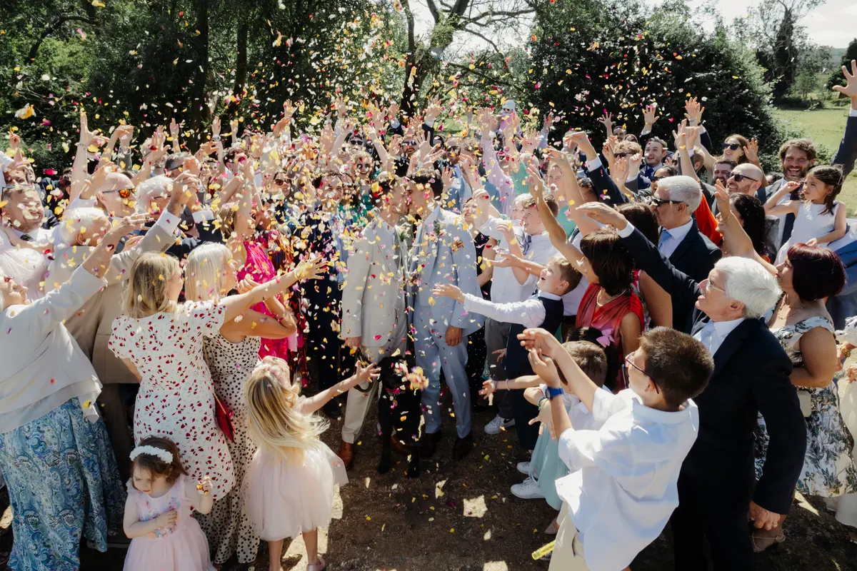 Confetti thrown over wedding couple by the river