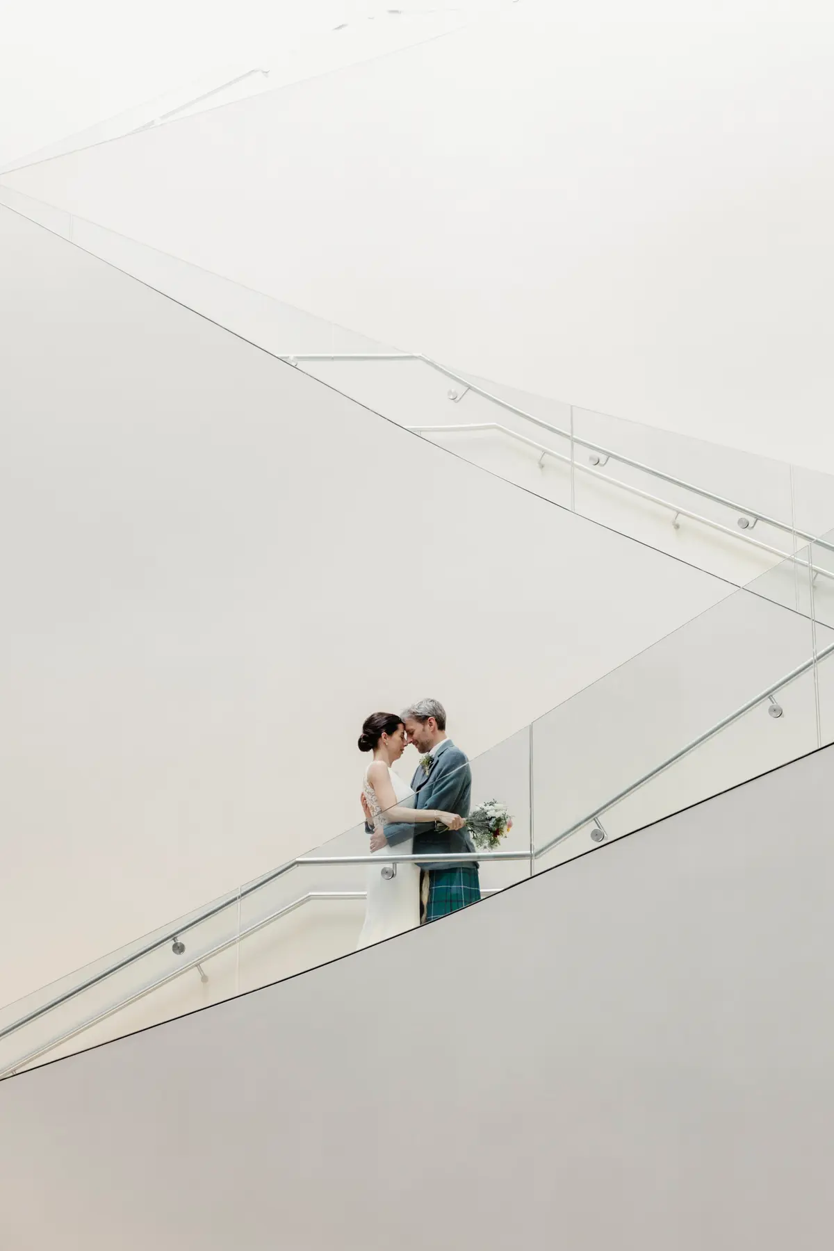 Wedding couple kissing on grand staircase at Ashmolean Museum Oxford