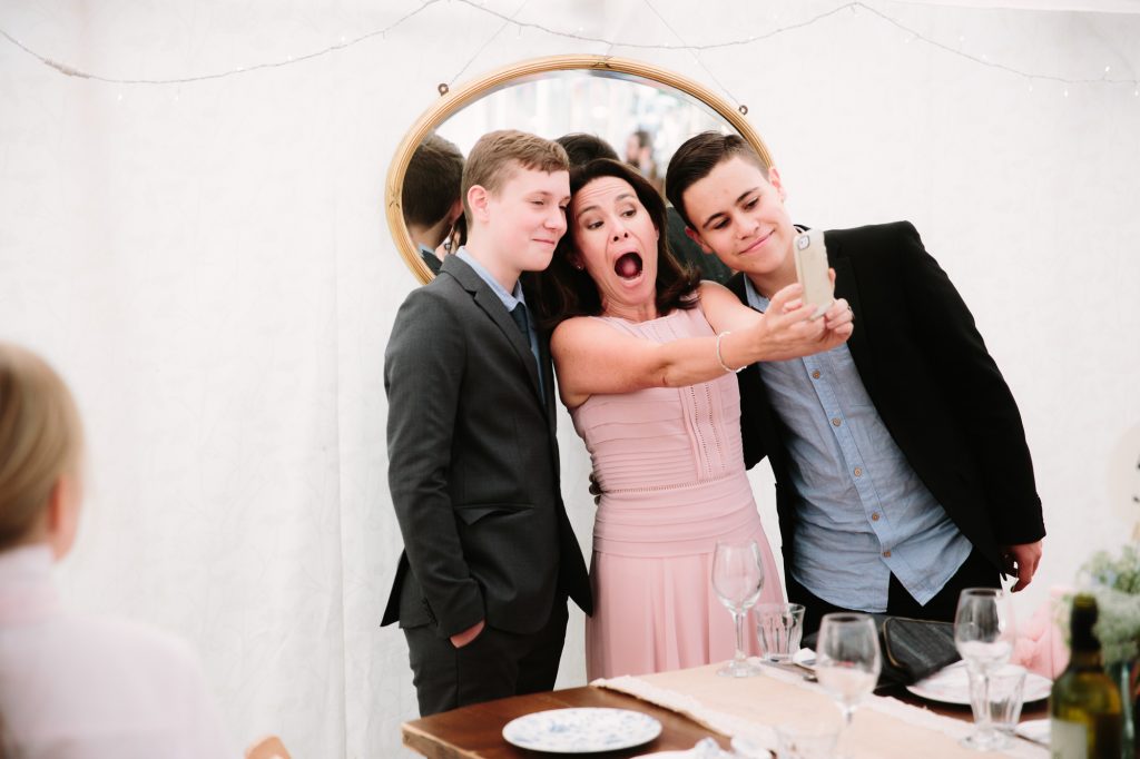 a mum taking a selfie of herself and her children at a relaxed oxford wedding