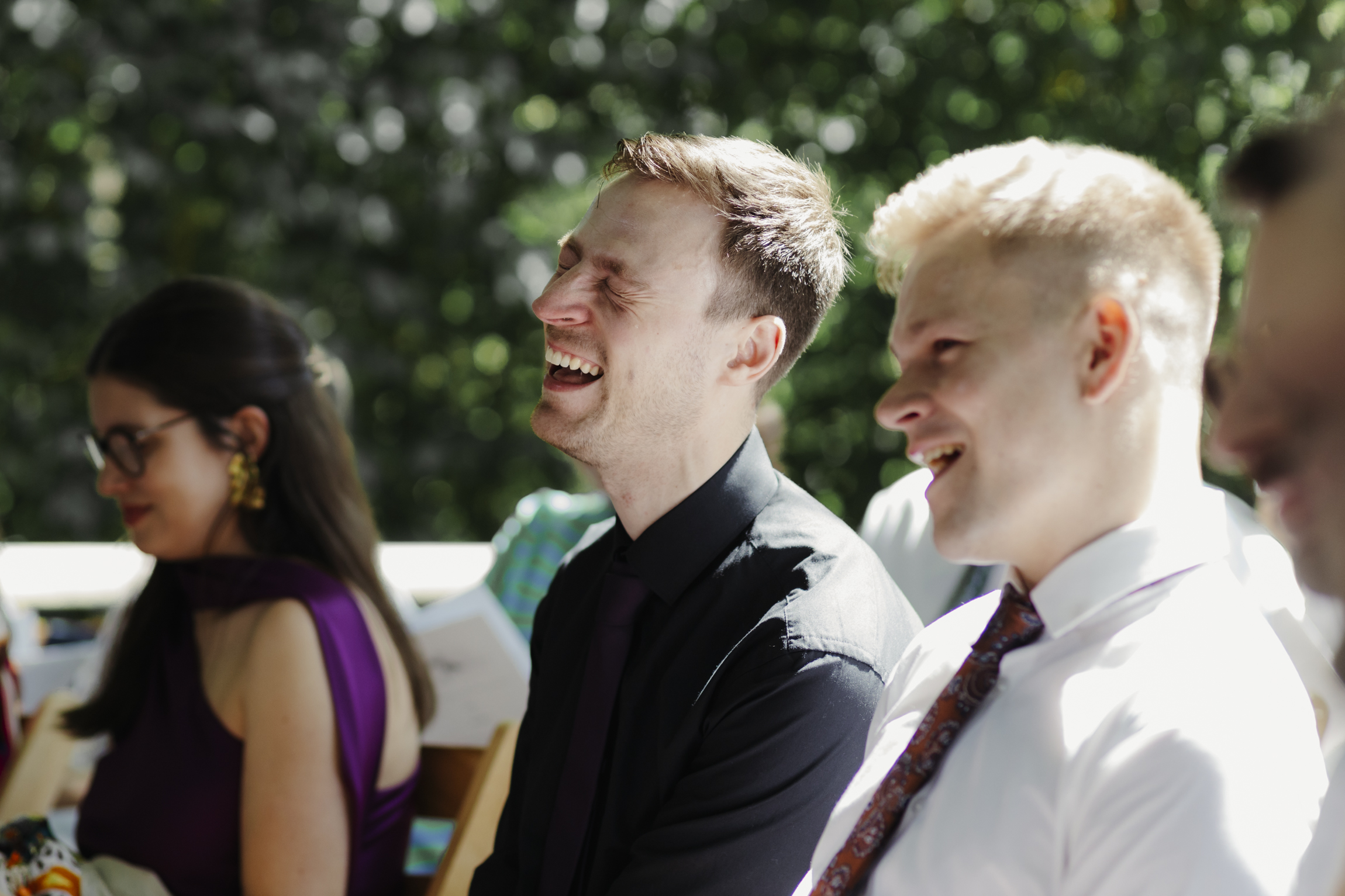 Guests watching outdoor wedding ceremony 
